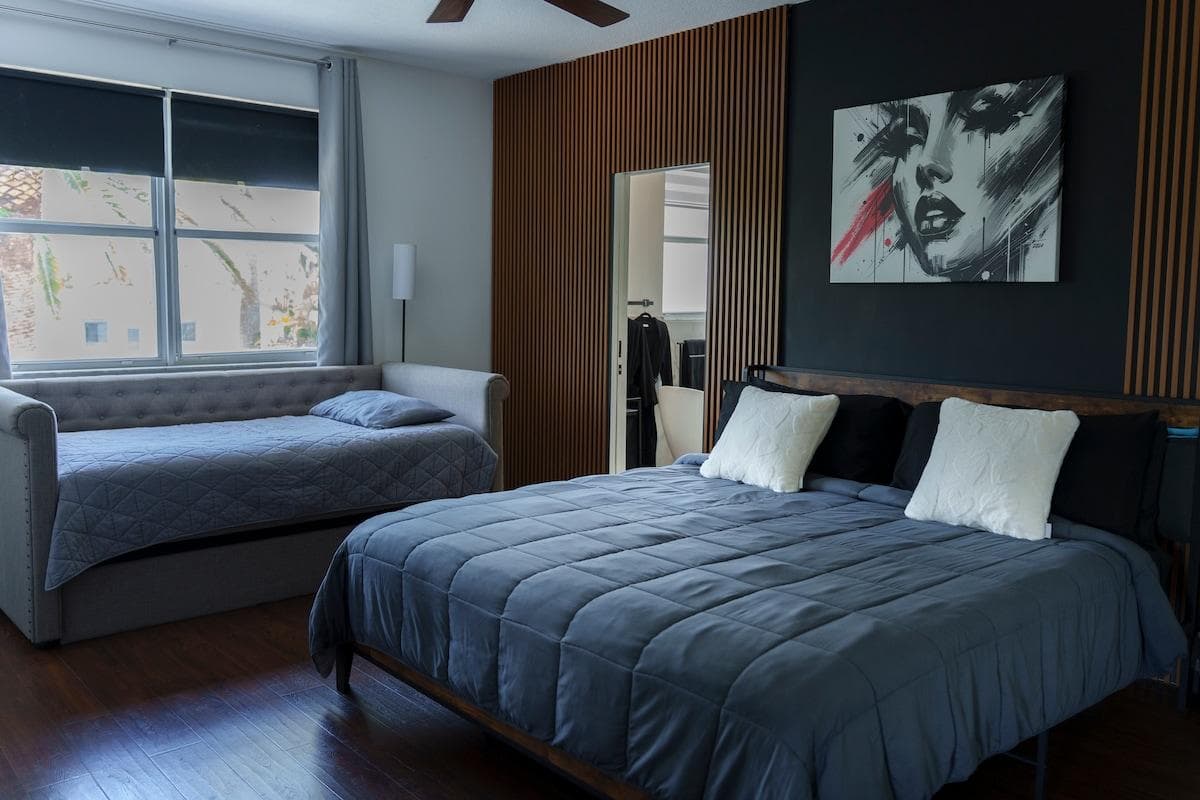 Spacious master suite with a king bed, twin daybed with trundle, Roku 55" smart TV, ensuite bath, and walk-in closet. Chic modern decor, cozy bedding, and room for the whole family to unwind in comfort. The perfect retreat for your stay!